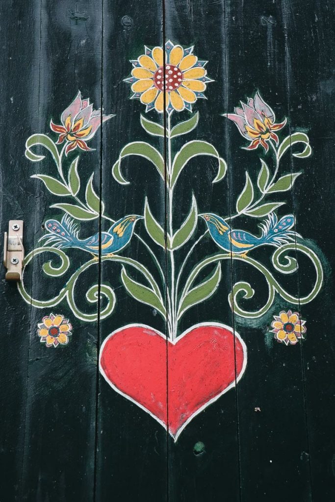 Détail de peinture sur bois Bauernmalerei avec motif de cœur et oiseaux sur un meuble traditionnel de la Forêt Noire