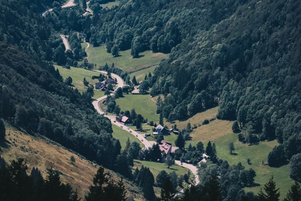Vue plongeante et aérienne sur un village traditionnel niché dans une vallée verdoyante de la Forêt Noire au pied du Feldberg