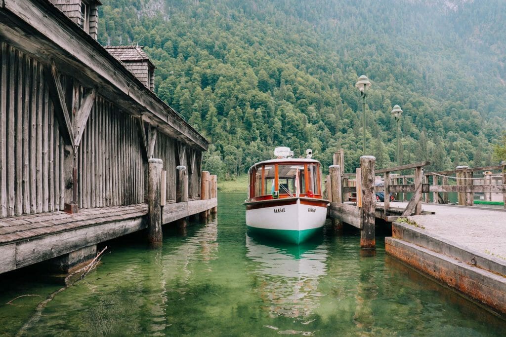 Bateau électrique traditionnel en bois à l'embarcadère du lac Königssee en Bavière au pied des montagnes boisées