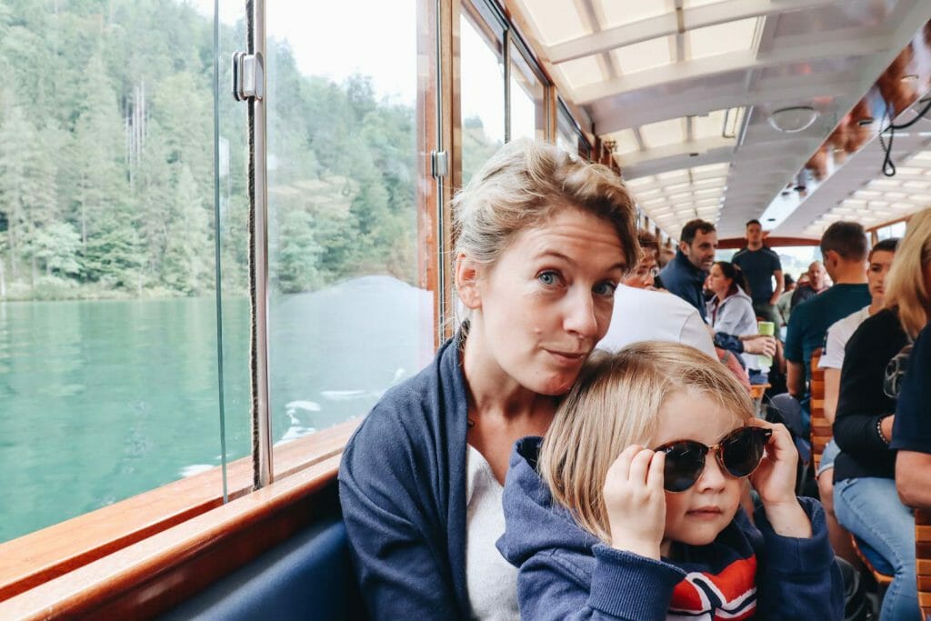 Mère et fille souriantes en famille à l'intérieur d'un bateau en bois sur le lac Königssee en Bavière