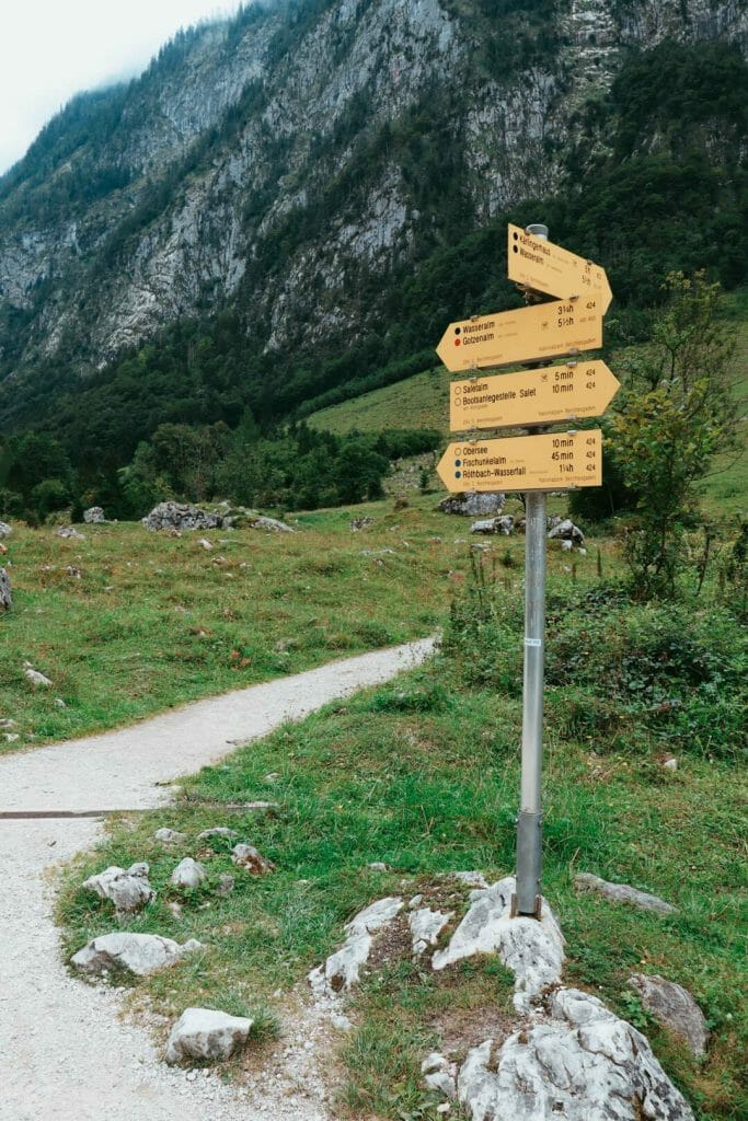 Panneaux de signalisation de randonnée en bois jaune indiquant les directions vers Königssee, Salet et la cascade de Röthbachfall en Bavière