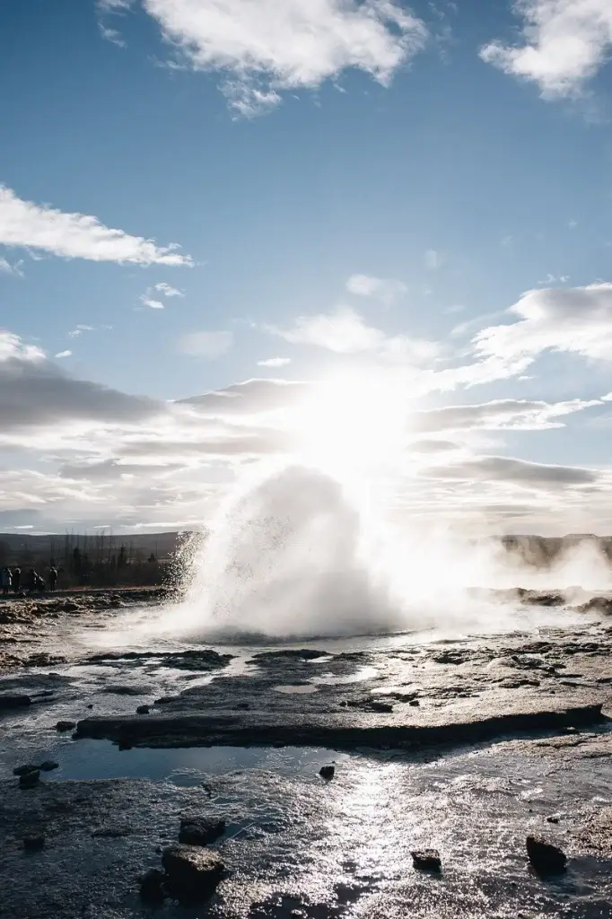 Bulle d'eau et vapeur du geyser Strokkur avec le soleil en arrière-plan en Islande.