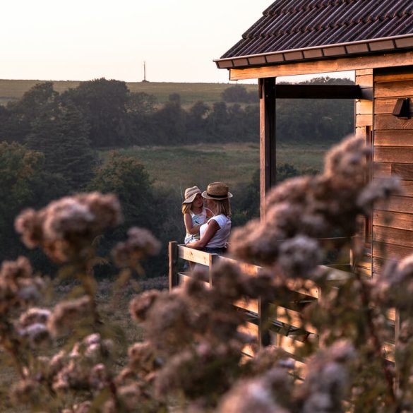 Mère et fille profitant du coucher de soleil sur la terrasse d'une cabane en bois en dans les Hauts de France