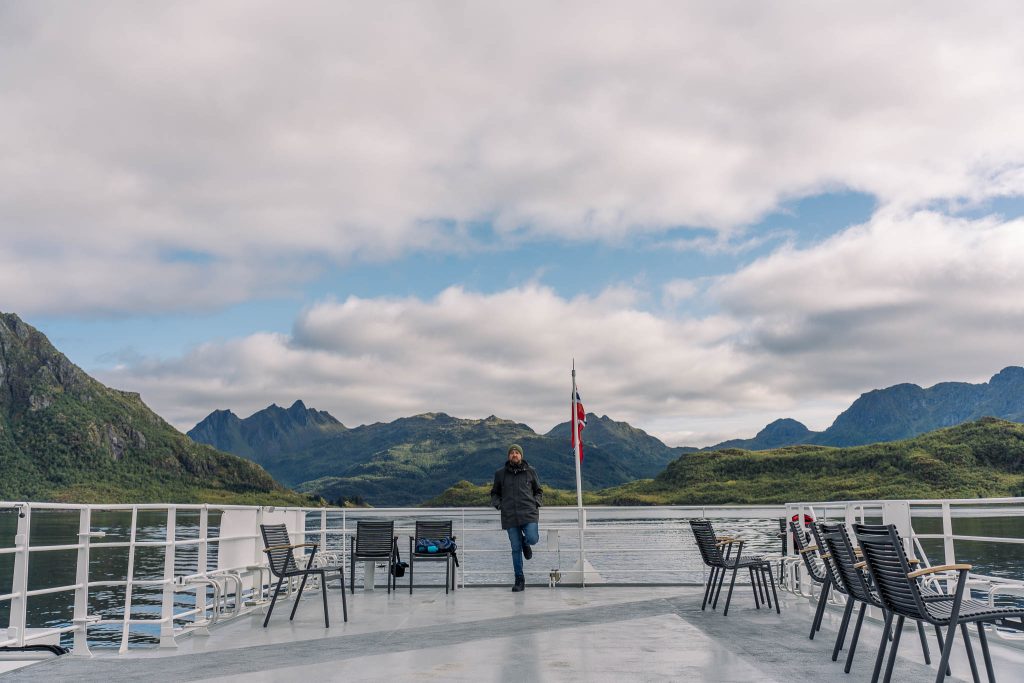 Homme sur le pont d'un bateau naviguant sur le Trollfjord