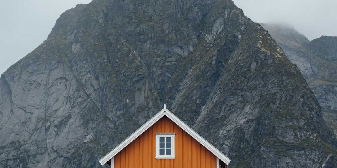Cabane de pêcheur jaune Sakrisøy avec montagne en fond