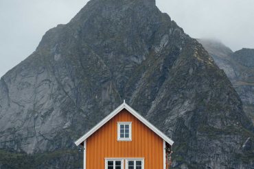 Cabane de pêcheur jaune Sakrisøy avec montagne en fond