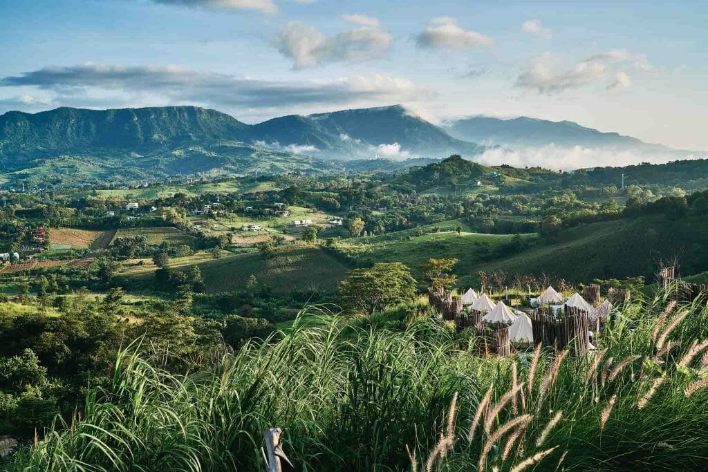 Spot de camping sauvage avec tentes au pied des montagnes verdoyantes de Thaïlande du Nord