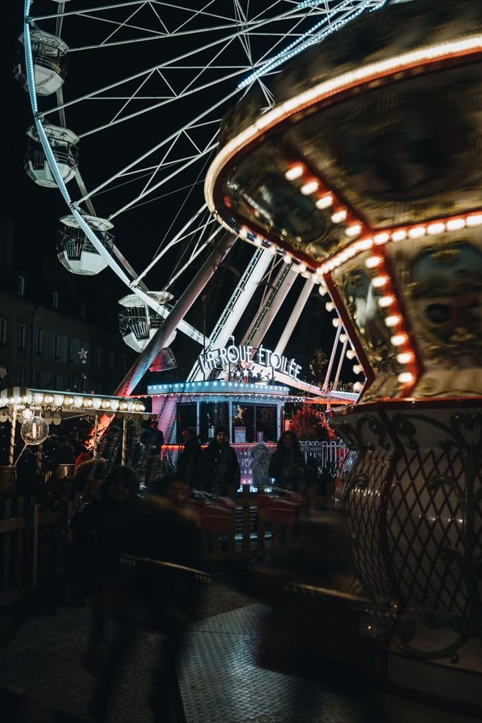manège balançoire éclairé par des lumières féériques pendant le marché de Noël de Nancy