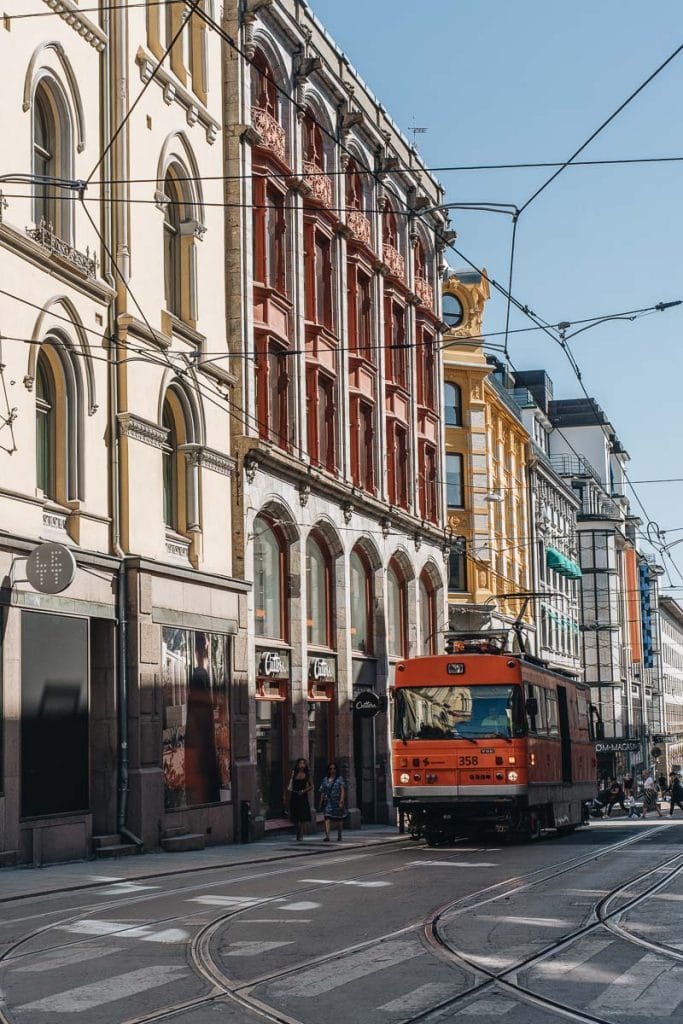 tramway typique circulant devant des façades néoclassiques colorées. dans le centre-ville d'Oslo