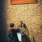 Enfant en robe de Gryffondor poussant le chariot de la voie 9 ¾ au studio Harry Potter de Tokyo