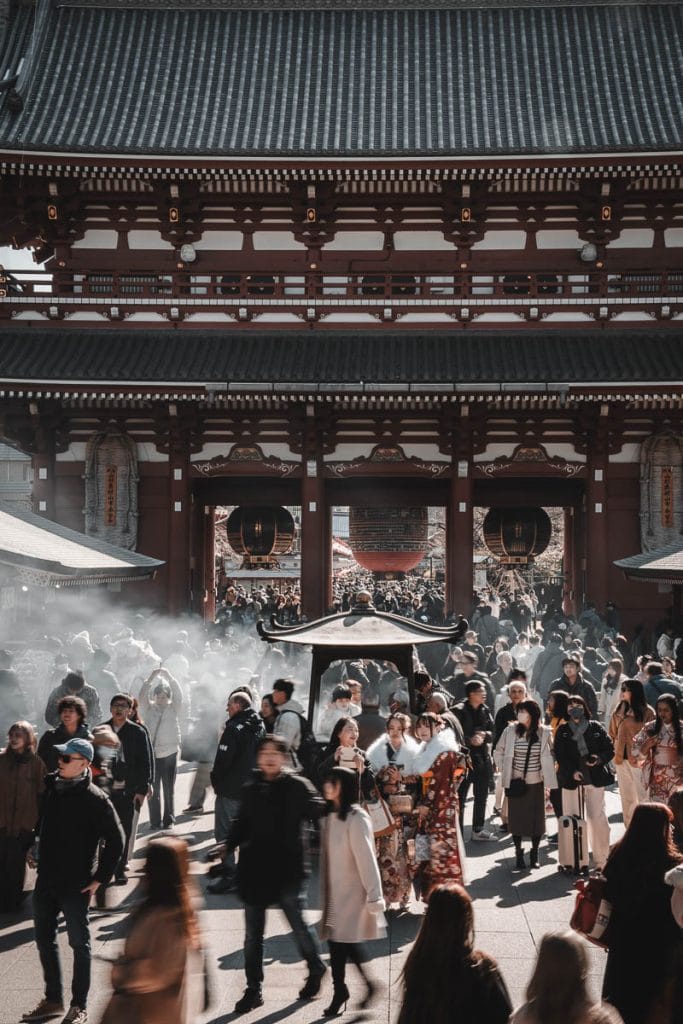 Vue sur la porte principale du temple Senso-ji à Asakusa avec une foule de visiteurs et de la fumée d'encens.