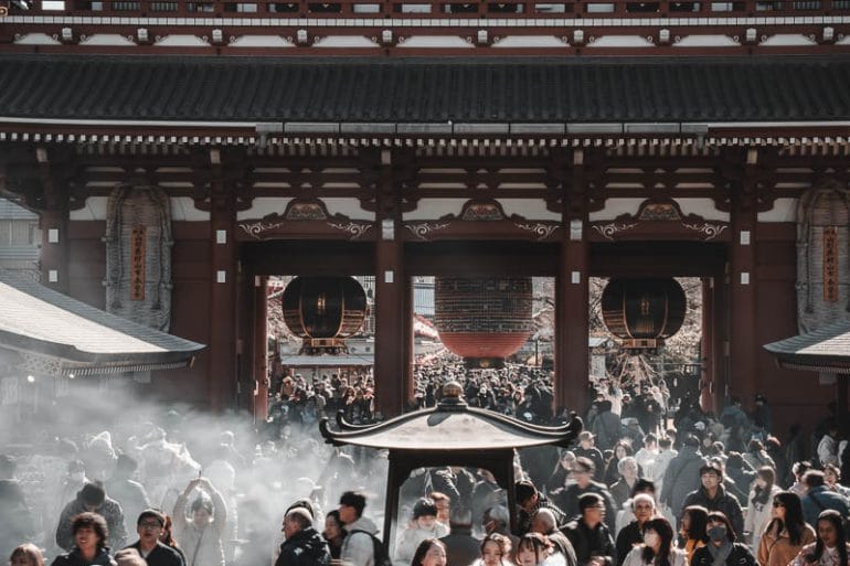 Vue sur la porte principale du temple Senso-ji à Asakusa avec une foule de visiteurs et de la fumée d'encens.