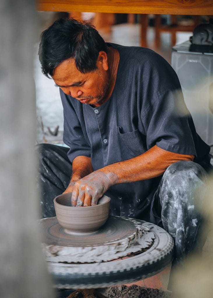 Artisan local travaillant l'argile sur un tour de potier traditionnel.