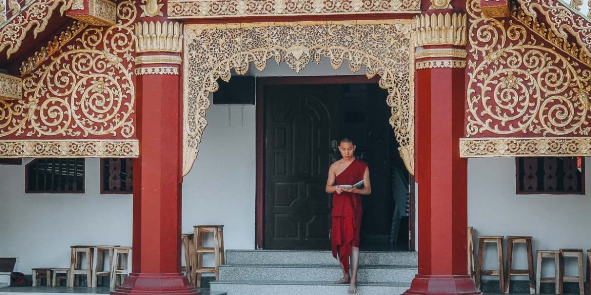 moine descendant les marches d'un temple en thailande