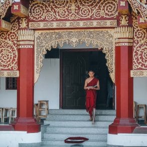 moine descendant les marches d'un temple en thailande