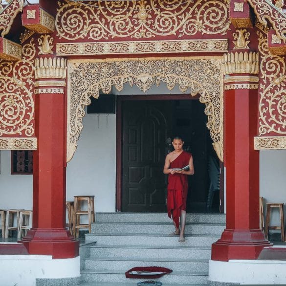 moine descendant les marches d'un temple en thailande