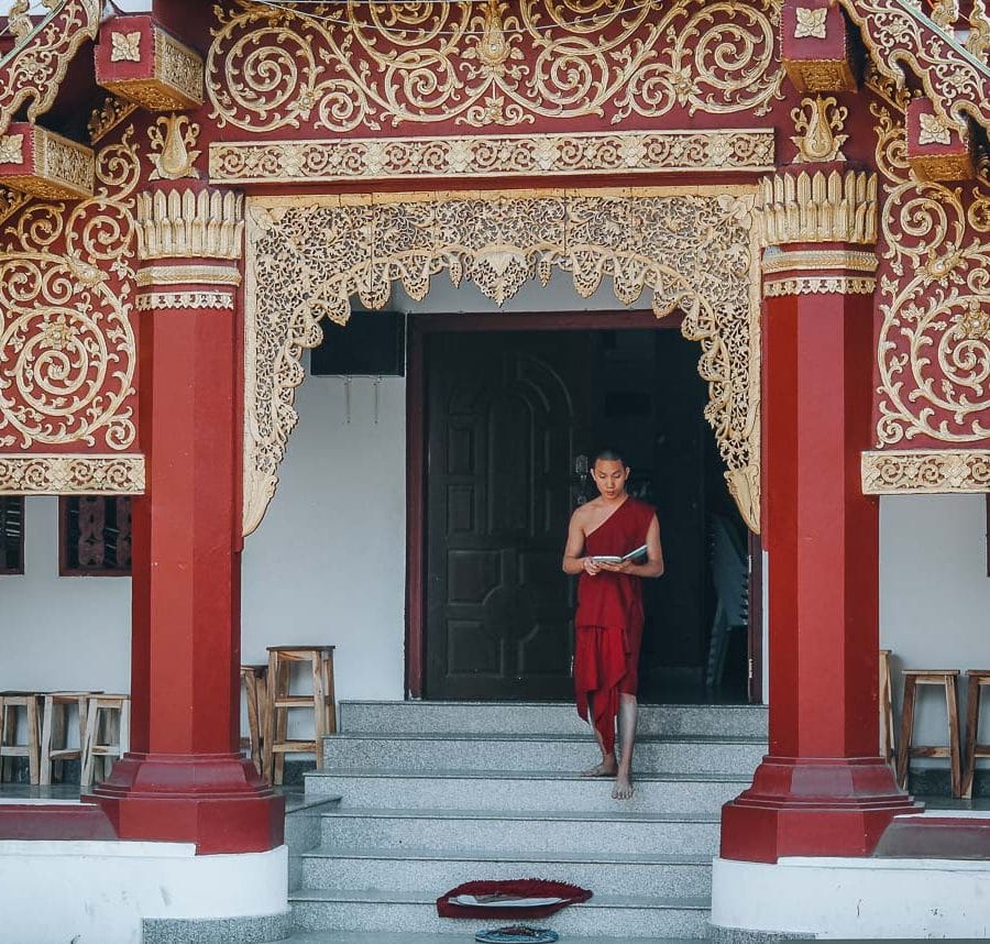 moine descendant les marches d'un temple en thailande