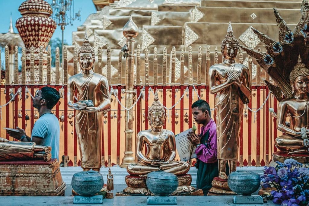 jeune homme thaï en train de prier dans un temple à Chiang Mai