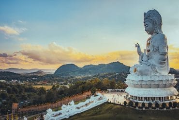 Vue panoramique sur l'immense statue de Guan Yin du Wat Huay Pla Kang à Chiang Rai, un incontournable de la Thaïlande du Nord au crépuscule.