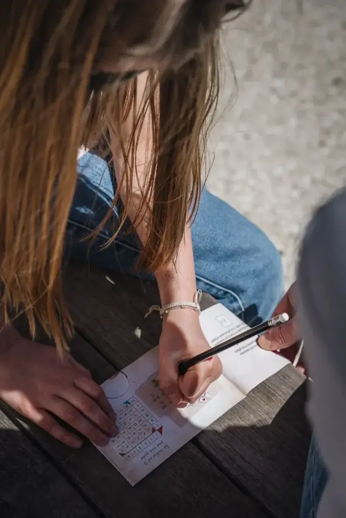 enfant remplit le carnet d'enquête du kit Intrigue dans la ville en famille