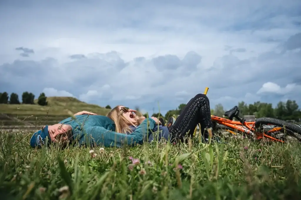 famille allongés dans l'herbe au lac de Monteux après quelques kilomètres à vélo