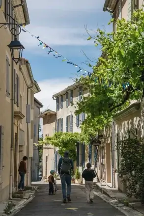 Balade dans une ruelle ornée de fanions à Pernes-les-Fontaines lors de la Mission GESTE artisans d'art