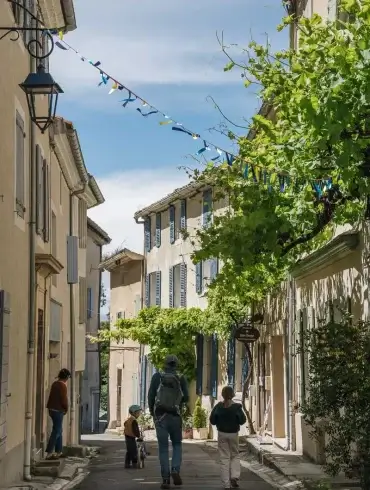 Balade dans une ruelle ornée de fanions à Pernes-les-Fontaines lors de la Mission GESTE artisans d'art
