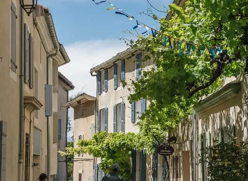 Balade dans une ruelle ornée de fanions à Pernes-les-Fontaines lors de la Mission GESTE artisans d'art