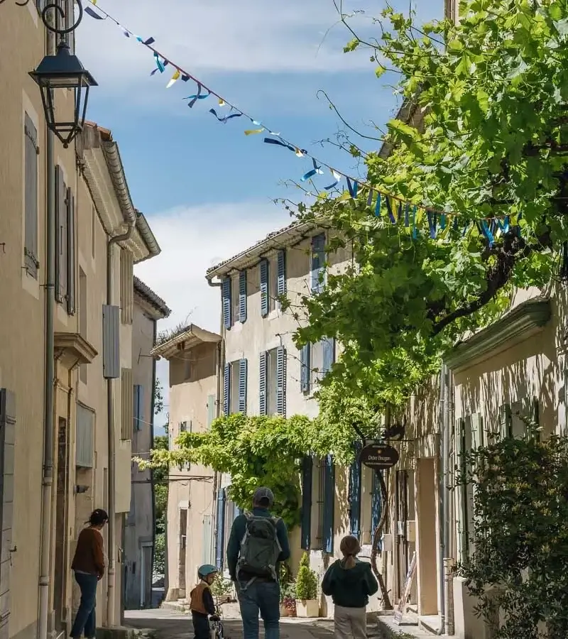 Balade dans une ruelle ornée de fanions à Pernes-les-Fontaines lors de la Mission GESTE artisans d'art