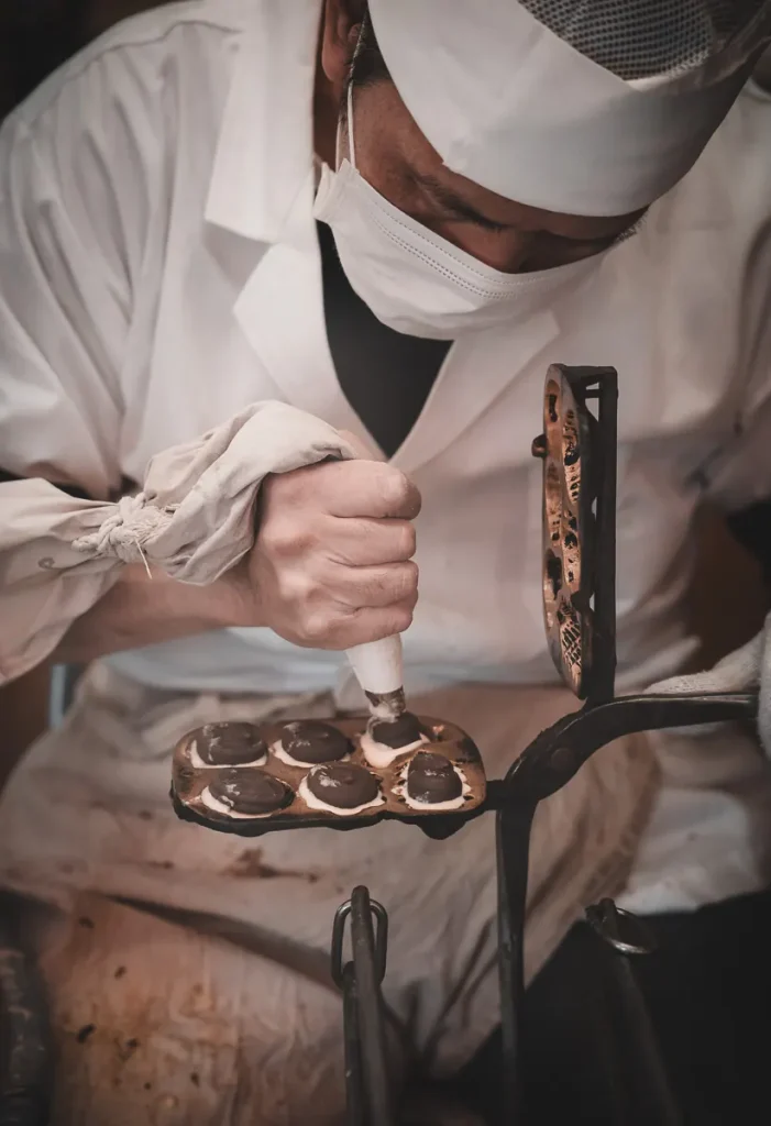 Artisan japonais préparant des taiyaki dans une boutique traditionnelle à Tokyo