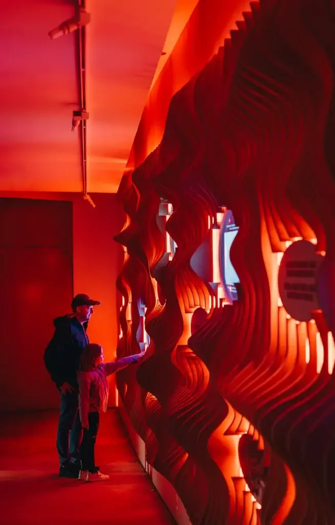 famille dans la salle rouge immersive du Centre d'Interprétation du Volcan Capelinhos à Faial, Açores