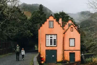 Maison orange typique dans le village de Furnas à São Miguel aux Açores, sous la brume