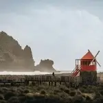 Moulin à vent rouge face aux vagues sur la côte de Pico aux Açores