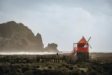 Moulin à vent rouge face aux vagues sur la côte de Pico aux Açores