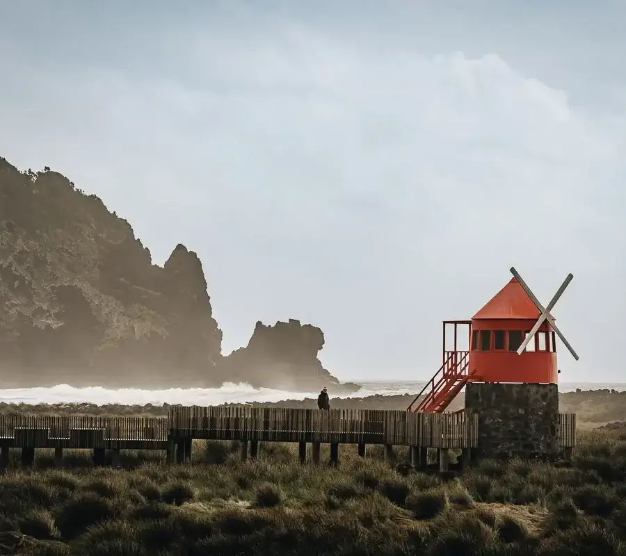 Moulin à vent rouge face aux vagues sur la côte de Pico aux Açores