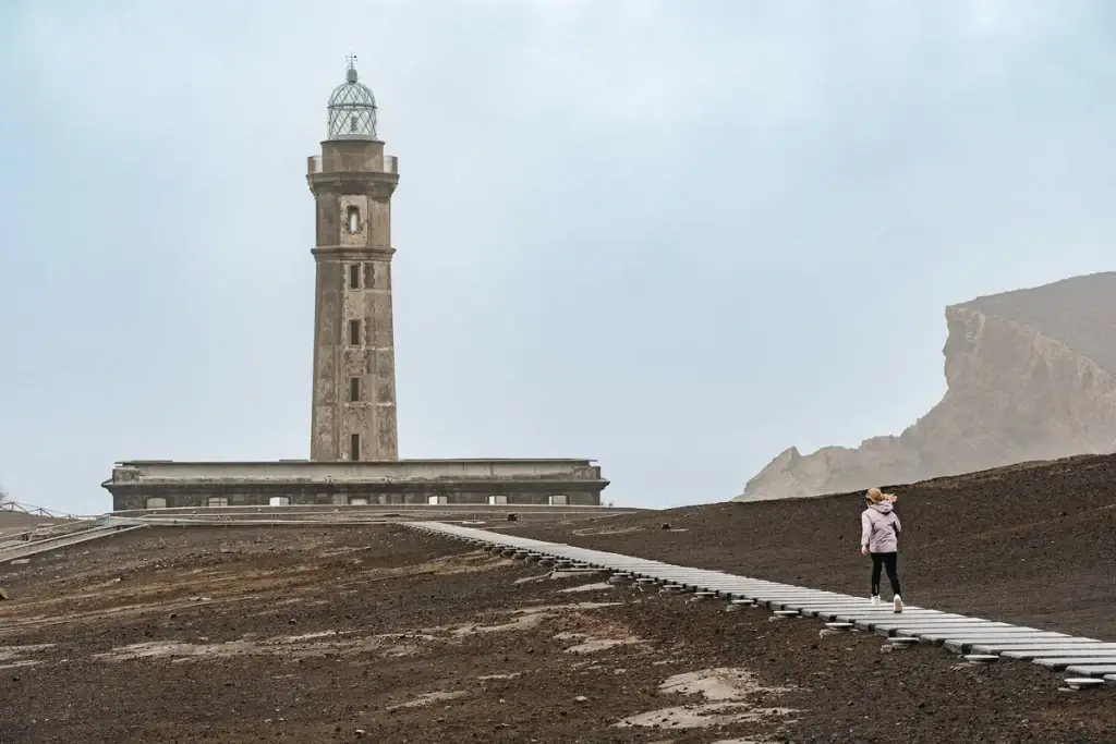 Fillette montant les escaliers en cendres volcaniques vers le phare de Capelinhos sur l'île de Faial aux Açores