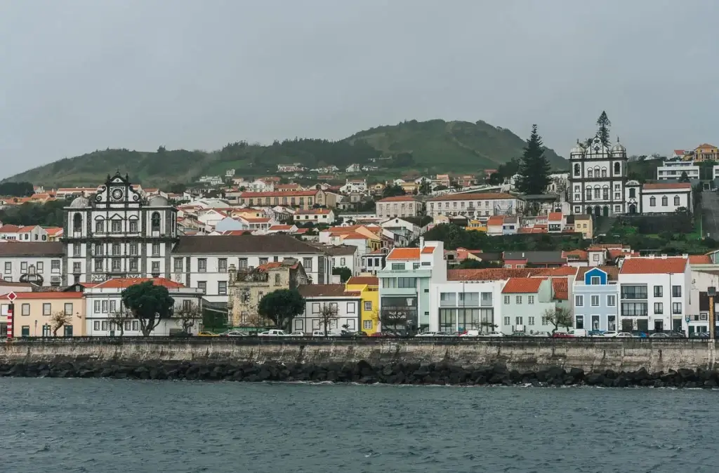 Vue sur la ville de Horta sur l'île de Faial aux Açores depuis le ferry, façades colorées et église baroque