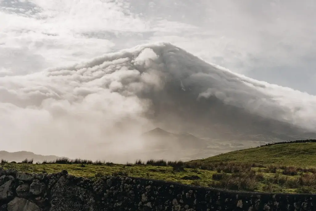 Le volcan Pico aux Açores avec son sommet entièrement enveloppé de nuages spectaculaires, vue depuis les prairies