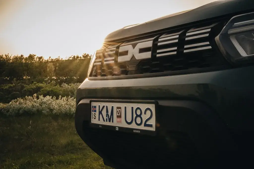 Zoom sur la calandre et la plaque d'immatriculation d'un Dacia Duster 4x4 de location en Islande en été