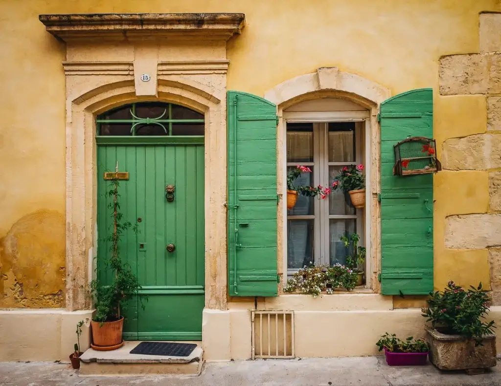 Façade authentique de Pézenas avec porte en bois et volets verts fleuris