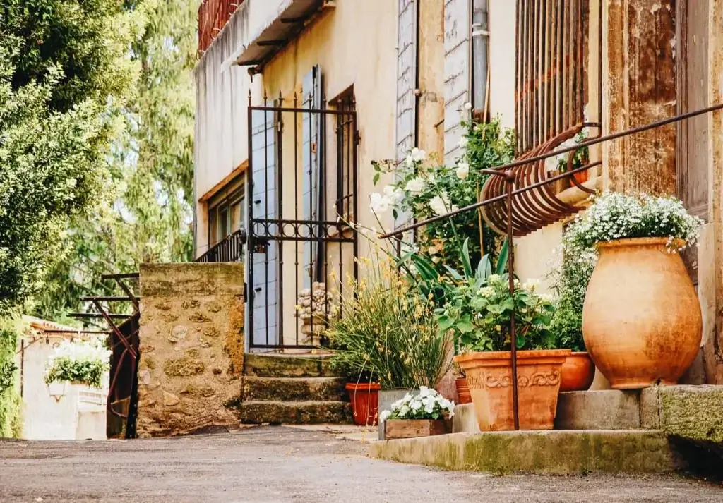 Ruelle pittoresque du centre historique de Pézenas bordée de poteries et jarres fleuries