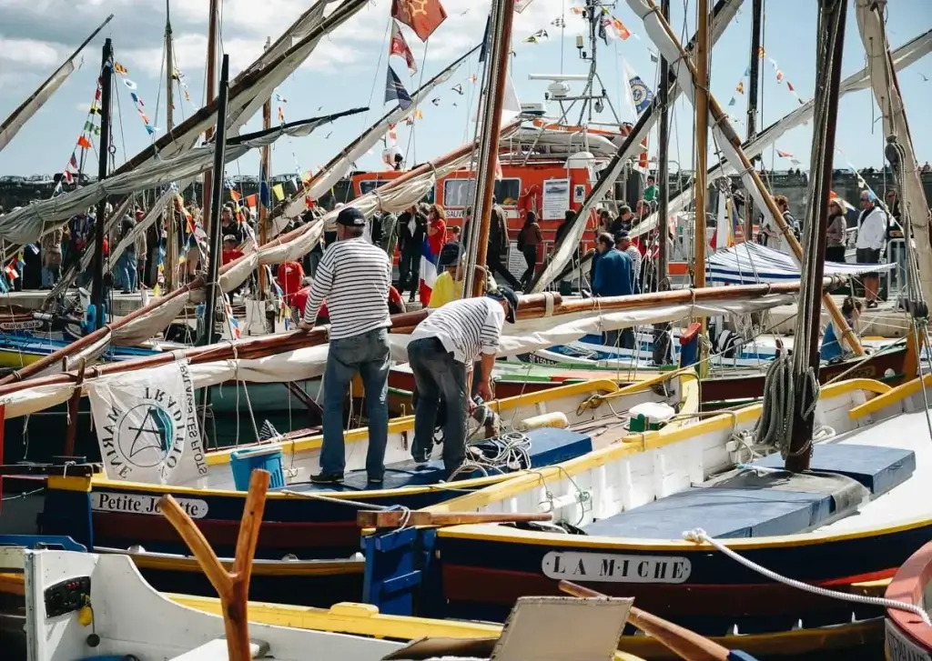 Marins s'affairant sur les bateaux de pêche traditionnels du port de Sète en été