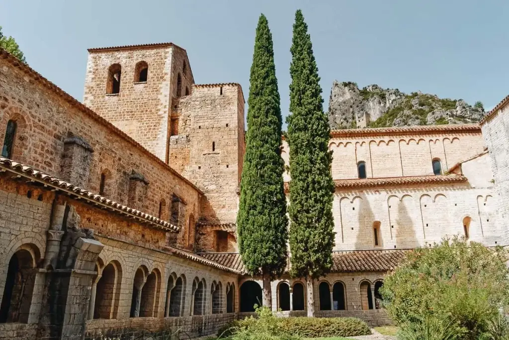 Abbaye de Gellone et grands cyprès dans le village médiéval de Saint-Guilhem-le-Désert dans l'Hérault cet été