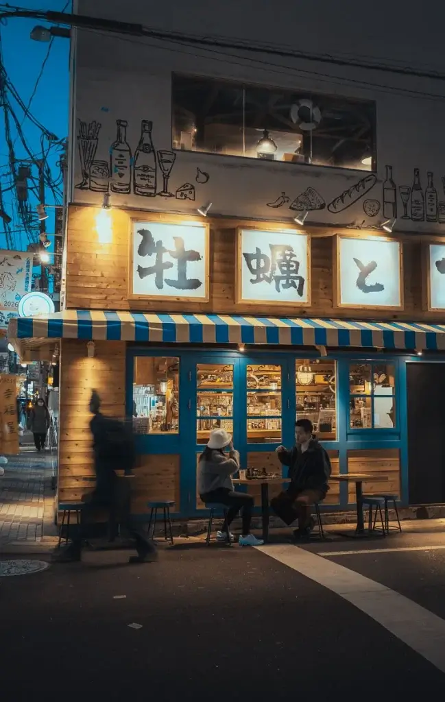Couple japonais devant un bar à huîtres la nuit à Dotonbori, à Osaka