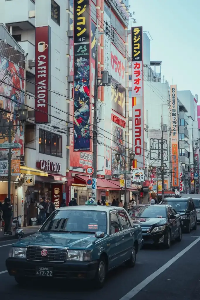 Rue de Den Den Town à Osaka, avec ses enseignes de gachapons, d’arcades et un taxi