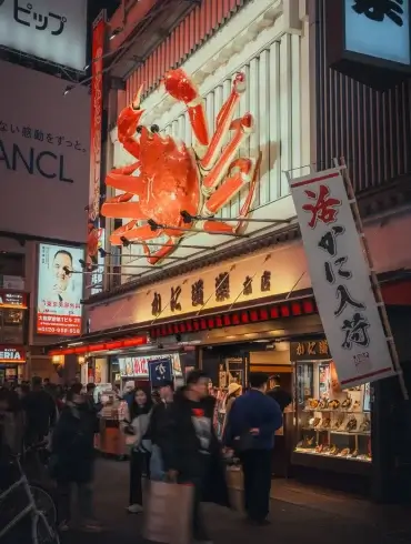 Crabe géant de l’enseigne Kani Doraku au-dessus de la foule à Dotonbori, à Osaka, la nuit