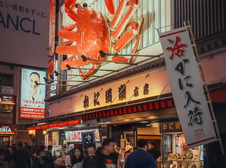 Crabe géant de l’enseigne Kani Doraku au-dessus de la foule à Dotonbori, à Osaka, la nuit