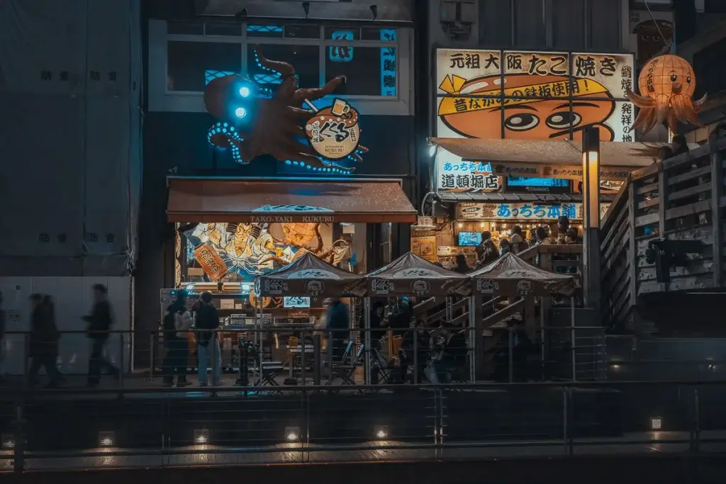 Canal de Dotonbori à Osaka la nuit, bordé de néons et d’enseignes lumineuses