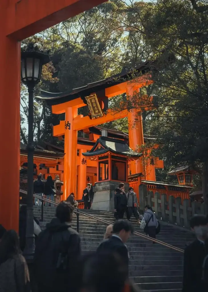 Grand torii vermillon et escaliers à l'entrée du sanctuaire Fushimi Inari, à Kyoto