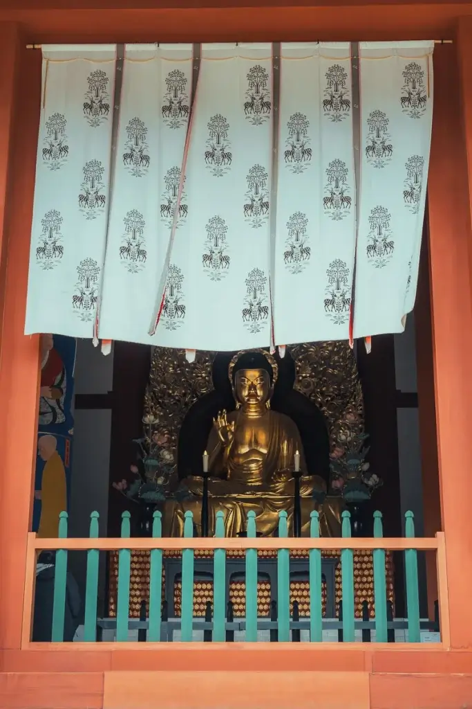 Bouddha doré du pavillon central Chūkondō du temple Kōfuku-ji à Nara, sous un rideau brodé de daims
